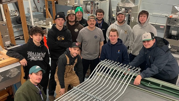 Students in Cape Tech’s Electrical Apprenticeship program working with bent electrical  conduit pipes used for a class project.